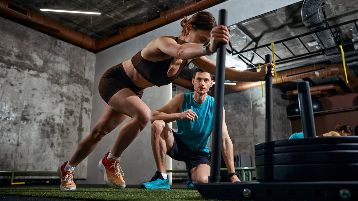 Supervised sled push conditioning drill in a performance gym